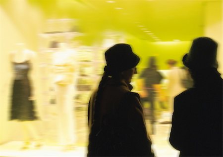shopfront - Silhouettes in front of clothing shop window, blurred Stock Photo - Premium Royalty-Free, Code: 695-03385295