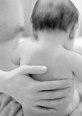 Mother's hand on infant's back, b&w Stock Photo - Premium Royalty-Free, Code: 695-03385493