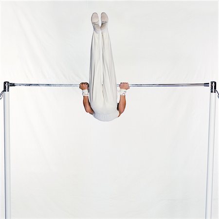 simsearch:632-01145004,k - Gymnaste masculin se balançant sur la barre horizontale Photographie de stock - Premium Libres de Droits, Code: 695-03386256