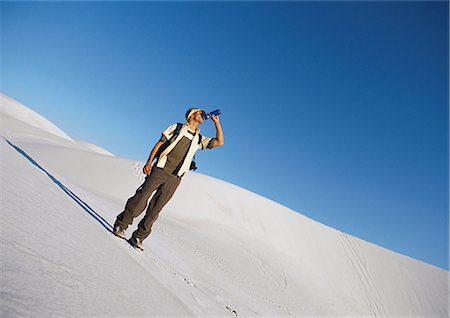 dune driving - Hiker standing on dune, drinking Stock Photo - Premium Royalty-Free, Code: 695-03386404