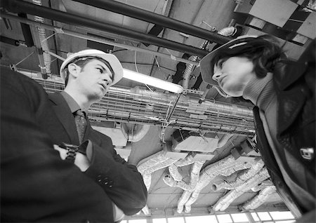 Man and woman wearing hard hats, low angle view Stock Photo - Premium Royalty-Free, Code: 695-03386669