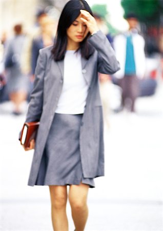 Businesswoman walking with book in hand Stock Photo - Premium Royalty-Free, Code: 695-03386801