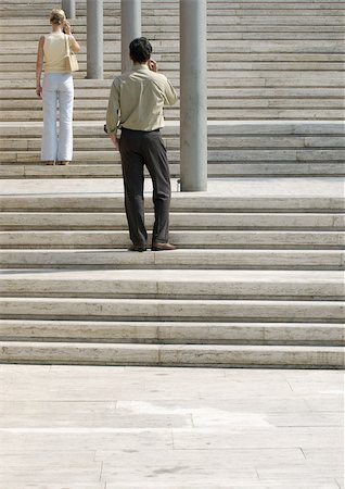 Man and woman standing on stairs outside, rear view Stock Photo - Premium Royalty-Free, Code: 695-03387251