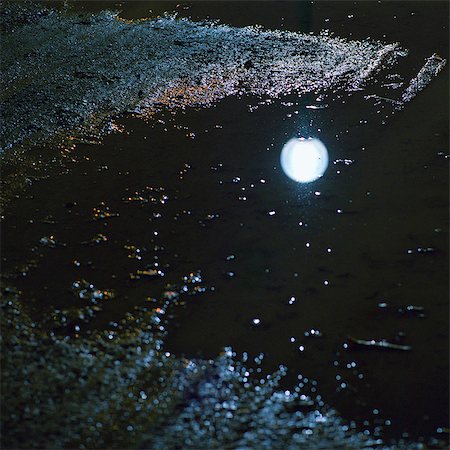 puddle in the rain - Reflection of street light in puddle, night Stock Photo - Premium Royalty-Free, Code: 695-03387320