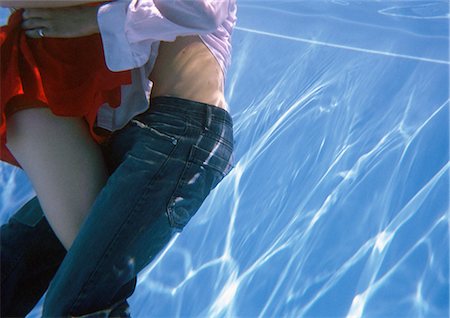 Fully clothed couple embracing in pool, underwater view Stock Photo - Premium Royalty-Free, Code: 695-03387606