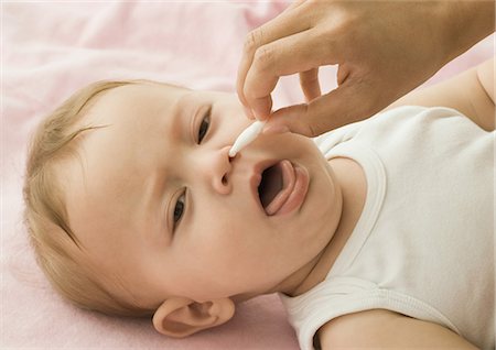 Baby having nose cleaned Stock Photo - Premium Royalty-Free, Code: 695-03388219