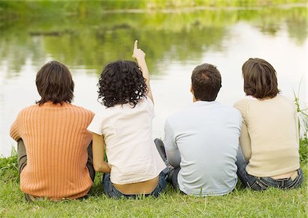 simsearch:695-03382482,k - Four friends sitting near the edge of a pond, one pointing, rear view Stock Photo - Premium Royalty-Free, Code: 695-03388525