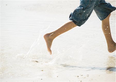 person stepping on a puddle - Child running in surf at the beach Stock Photo - Premium Royalty-Free, Code: 695-03388583