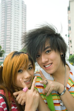 simsearch:694-03318481,k - Teenage couple making peace signs Stock Photo - Premium Royalty-Free, Code: 695-03388896
