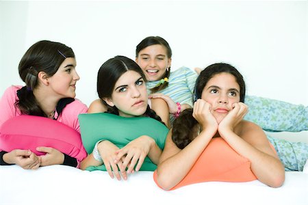 Four young female friends reclining with cushions and looking away Stock Photo - Premium Royalty-Free, Code: 695-03389227