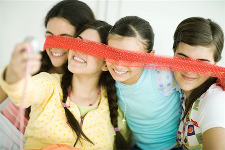 simsearch:696-03394065,k - Four young female friends holding scarf in front of eyes, one taking photo with cell phone Foto de stock - Sin royalties Premium, Código: 695-03389239