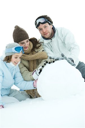 simsearch:695-03388794,k - Three young friends making snowball, dressed in winter clothing, one looking at camera Stock Photo - Premium Royalty-Free, Code: 695-03389297