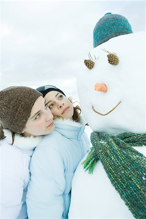 simsearch:695-03376367,k - Two young friends looking at snowman together, one leaning on the other's shoulder Stock Photo - Premium Royalty-Free, Code: 695-03389300