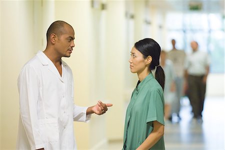 simsearch:694-03331631,k - Medical staff standing  face to face in hallway, discussing Stock Photo - Premium Royalty-Free, Code: 695-03389314