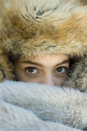 Preteen girl, wearing fur hat, looking over fur blanket, close-up Stock Photo - Premium Royalty-Free, Code: 695-03389318