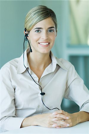 switchboard operator - Young businesswoman wearing headset, smiling at camera, waist up Stock Photo - Premium Royalty-Free, Code: 695-03389339