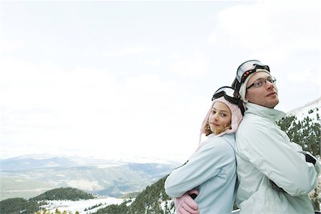 simsearch:695-03376478,k - Young man and teen girl skiers standing back to back, smiling, girl looking at camera, portrait Foto de stock - Sin royalties Premium, Código: 695-03389442