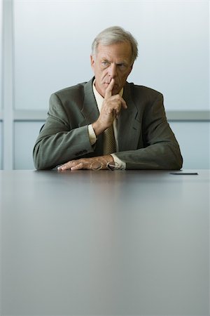 shhh - Businessman holding finger to lips, looking away Stock Photo - Premium Royalty-Free, Code: 695-03389628