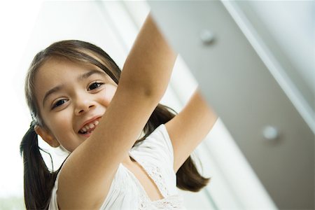 simsearch:632-01193783,k - Little girl with pigtails smiling at camera, arms raised, portrait Stock Photo - Premium Royalty-Free, Code: 695-03389779