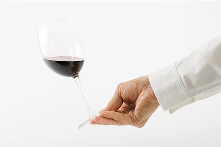 simsearch:640-02770391,k - Hand tipping glass of red wine Stock Photo - Premium Royalty-Free, Code: 695-03389897