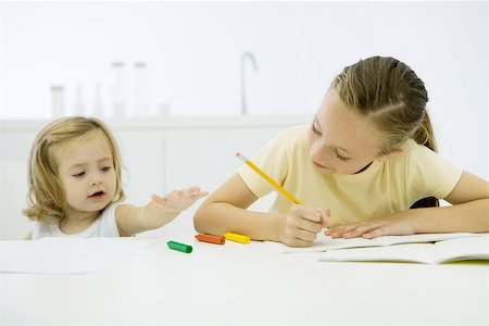 pencil crayon - Girl doing homework, younger sister reaching for markers Foto de stock - Sin royalties Premium, Código: 695-03389993