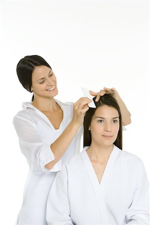 simsearch:693-06323962,k - Hair stylist combing woman's hair, both looking away Stock Photo - Premium Royalty-Free, Code: 695-03380198
