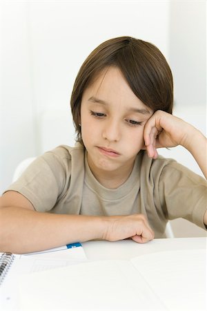 simsearch:695-03380694,k - Boy sitting at table looking at homework, frowning Stock Photo - Premium Royalty-Free, Code: 695-03380345