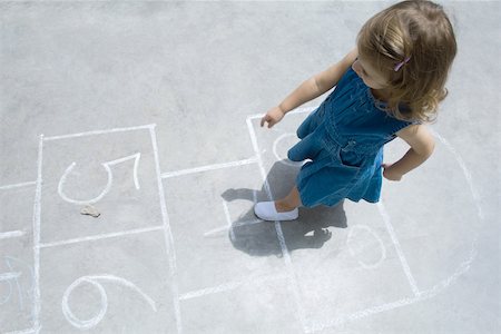 Little girl playing hopscotch outdoors, overhead view Stock Photo - Premium Royalty-Free, Code: 695-03380686