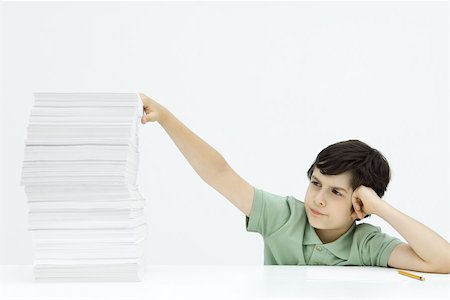 simsearch:695-03380694,k - Boy sitting with tall stack of papers, holding head, frowning Stock Photo - Premium Royalty-Free, Code: 695-03380696
