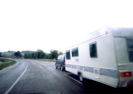 Car with mobile home driving on road, blurry. Stock Photo - Premium Royalty-Free, Code: 695-03380955