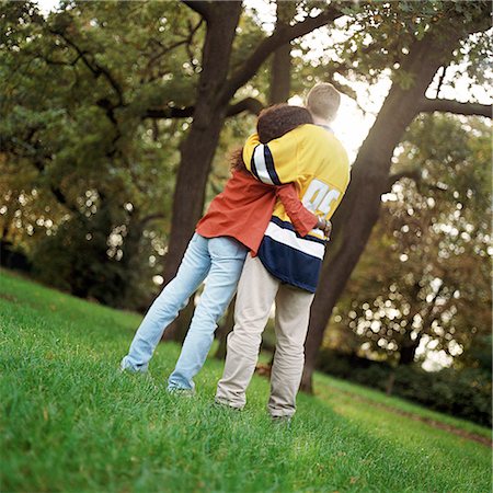simsearch:695-03382482,k - Young man and woman standing on grass, embracing, rear view, full length Stock Photo - Premium Royalty-Free, Code: 695-03382467