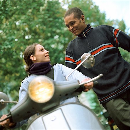simsearch:695-03382482,k - Young man standing next to young woman on motor scooter, low angle view Stock Photo - Premium Royalty-Free, Code: 695-03382484