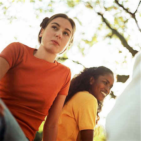 simsearch:695-03382482,k - Young women sitting next to each other outside, low angle view Stock Photo - Premium Royalty-Free, Code: 695-03382512