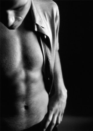 Man standing with shirt open, hand on waistband and head down, close-up, black and white. Foto de stock - Sin royalties Premium, Código: 695-03382653