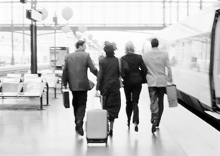 simsearch:695-03386286,k - Group of business people walking on train platform, rear view, b&w. Stock Photo - Premium Royalty-Free, Code: 695-03382942