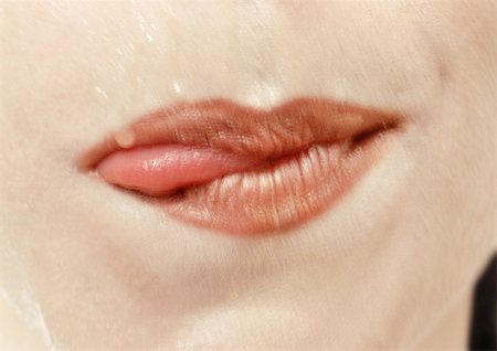 Close up of woman's mouth with tongue sticking out the side. Foto de stock - Sin royalties Premium, Código: 695-03383293