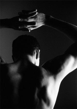 Man with clasped hands above head, rear view, black and white, silhouette. Stock Photo - Premium Royalty-Free, Code: 695-03383536