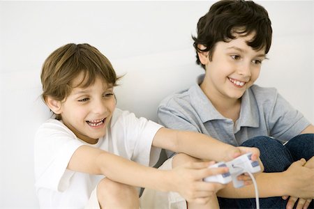 simsearch:695-05779519,k - Deux garçons jouant ensemble, jeux vidéo, contrôleur d'une exploitation, les deux souriant Photographie de stock - Premium Libres de Droits, Code: 695-03390105