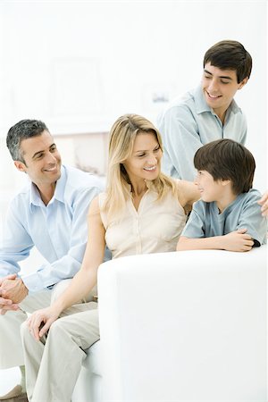 simsearch:632-05816381,k - Family together on sofa, mother's arm around younger son's shoulder Stock Photo - Premium Royalty-Free, Code: 695-03390229