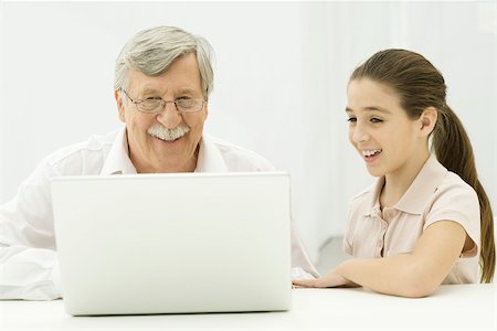 preteen girls looking older - Grandfather and granddaughter looking at laptop together Stock Photo - Premium Royalty-Free, Code: 695-03390318