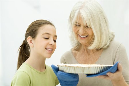 preteen girls looking older - Grandmother and granddaughter looking down at freshly baked pie Stock Photo - Premium Royalty-Free, Code: 695-03390325