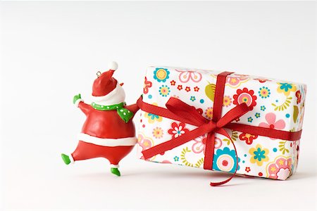 Santa Claus figurine pulling Christmas present Stock Photo - Premium Royalty-Free, Code: 695-03390339