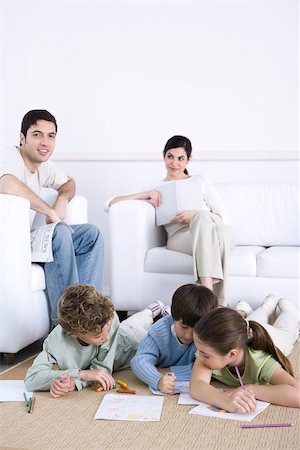 simsearch:695-03378605,k - Family relaxing together in living room, children coloring on floor, father smiling at camera Stock Photo - Premium Royalty-Free, Code: 695-03390379