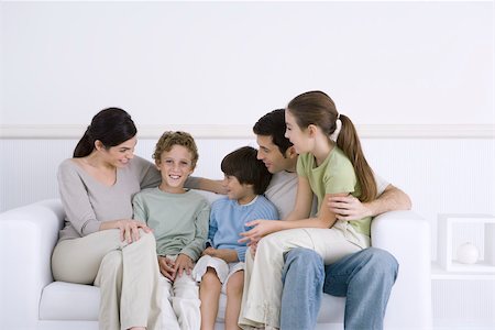 simsearch:695-05769087,k - Family with three children sitting together on sofa, one boy smiling at camera Stock Photo - Premium Royalty-Free, Code: 695-03390381