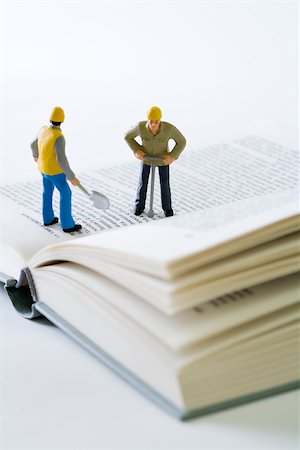 Miniature construction workers standing on open book Stock Photo - Premium Royalty-Free, Code: 695-03390437