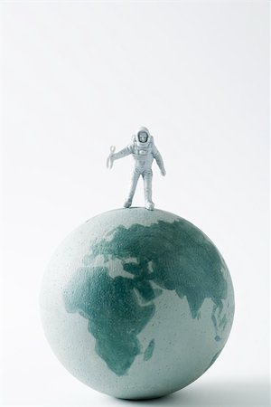 Miniature astronaut standing on top of globe Stock Photo - Premium Royalty-Free, Code: 695-03390443