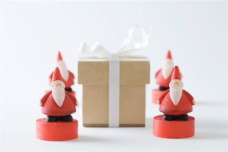 simsearch:6113-07790394,k - Santa Claus figurines arranged around Christmas gift Stock Photo - Premium Royalty-Free, Code: 695-03390452