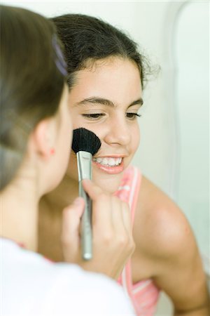 simsearch:695-03388794,k - Two young female friends, one putting make-up on the other Stock Photo - Premium Royalty-Free, Code: 696-03394070