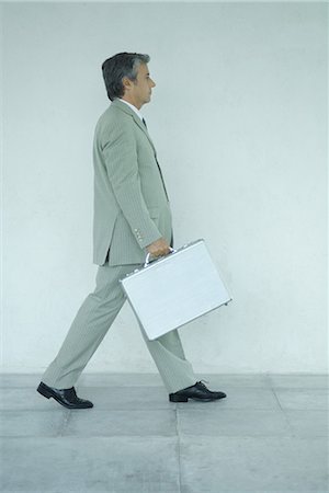 simsearch:695-03378125,k - Businessman carrying briefcase, side view, full length portrait Stock Photo - Premium Royalty-Free, Code: 696-03394121