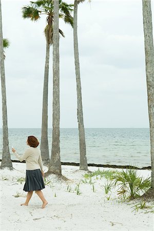 simsearch:695-03376228,k - Woman walking on beach, looking at cell phone, full length Stock Photo - Premium Royalty-Free, Code: 696-03394639